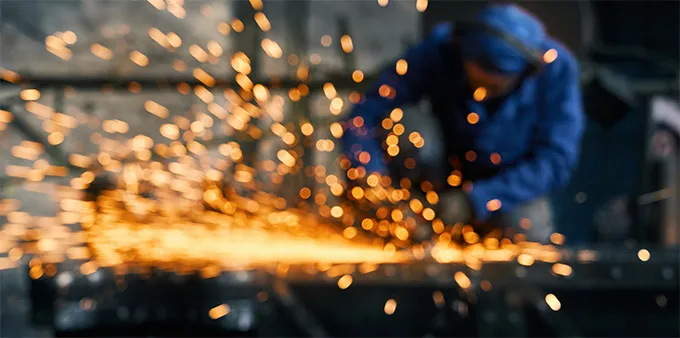 worker fabricating gate by electric steel cutter machine